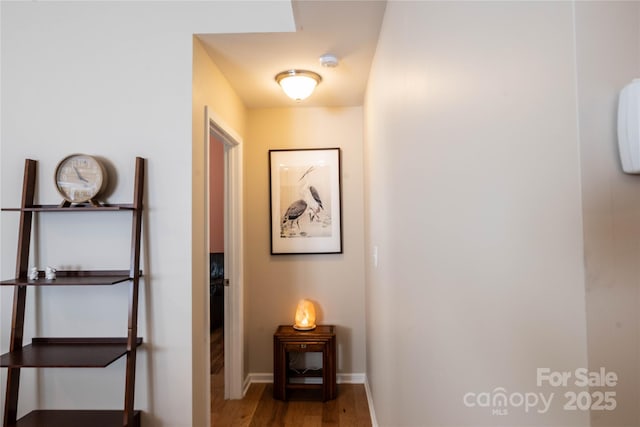 corridor featuring wood finished floors and baseboards