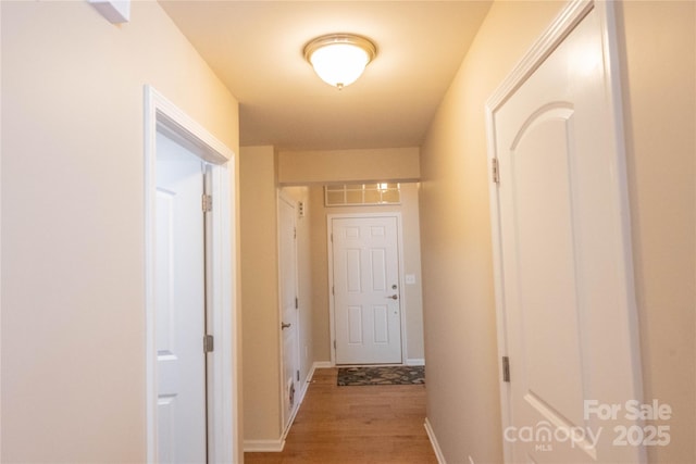 hall with light wood finished floors and baseboards