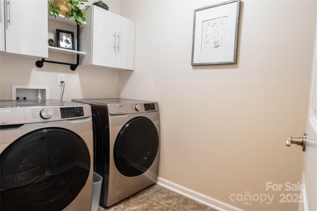 laundry area with baseboards, cabinet space, and independent washer and dryer