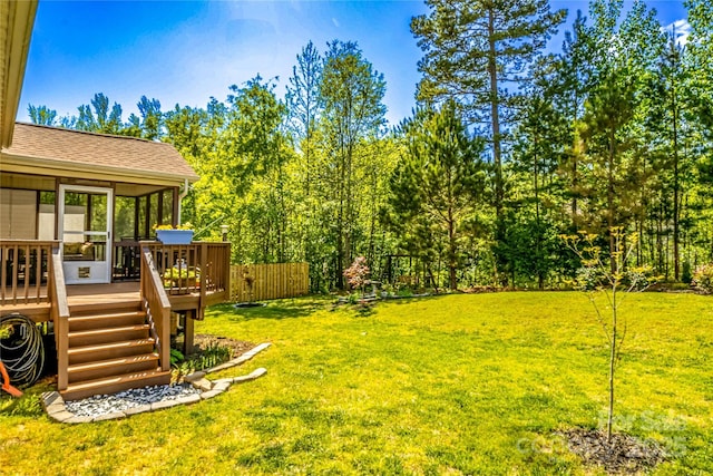 view of yard featuring a sunroom and a deck