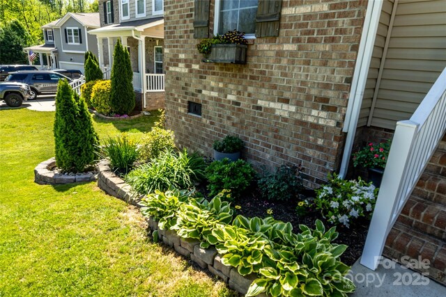 view of side of property featuring a yard and brick siding