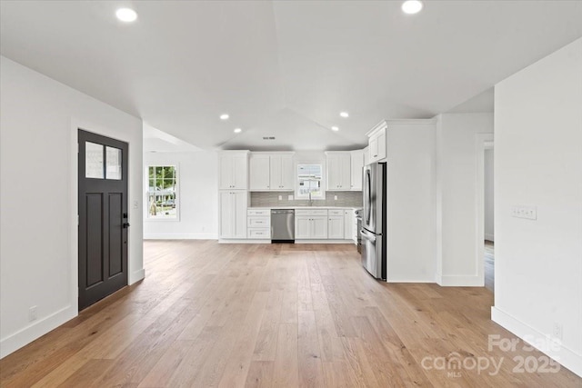 2429/2425 Ellen Ave, Charlotte, NC 28208 - kitchen with white cabinets, lofted ceiling, light countertops, a sink, and appliances with stainless steel finishes