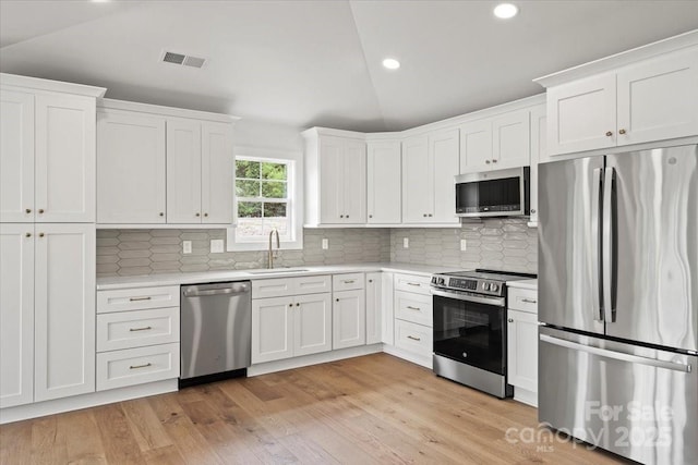 2429/2425 Ellen Ave, Charlotte, NC 28208 - kitchen with lofted ceiling, light countertops, a sink, and appliances with stainless steel finishes