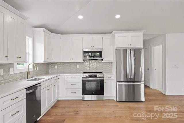 2429/2425 Ellen Ave, Charlotte, NC 28208 - kitchen with white cabinets, recessed lighting, light countertops, a sink, and appliances with stainless steel finishes