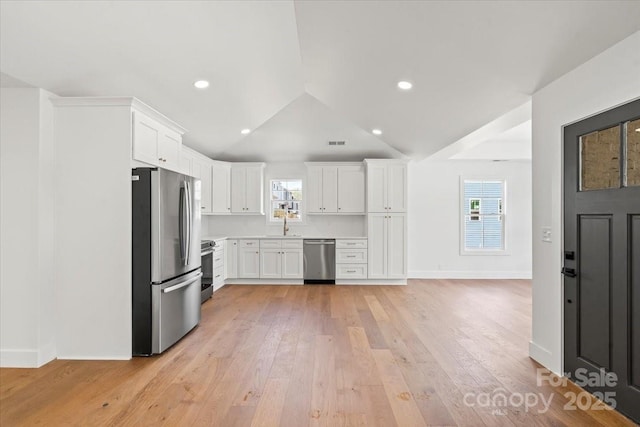 2429/2425 Ellen Ave, Charlotte, NC 28208 - kitchen featuring light wood finished floors, white cabinetry, lofted ceiling, light countertops, and appliances with stainless steel finishes