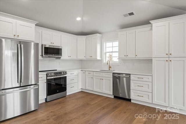 2429/2425 Ellen Ave, Charlotte, NC 28208 - kitchen featuring light countertops, visible vents, appliances with stainless steel finishes, and white cabinets