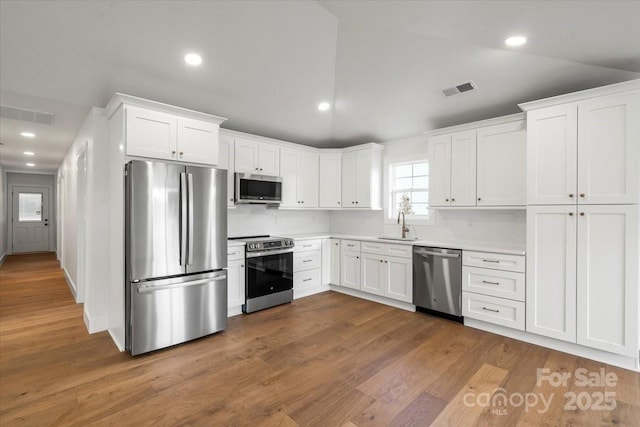 2429/2425 Ellen Ave, Charlotte, NC 28208 - kitchen featuring white cabinets, stainless steel appliances, visible vents, and a sink