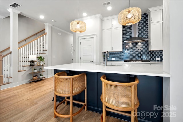 kitchen featuring a sink, cooktop, tasteful backsplash, and visible vents