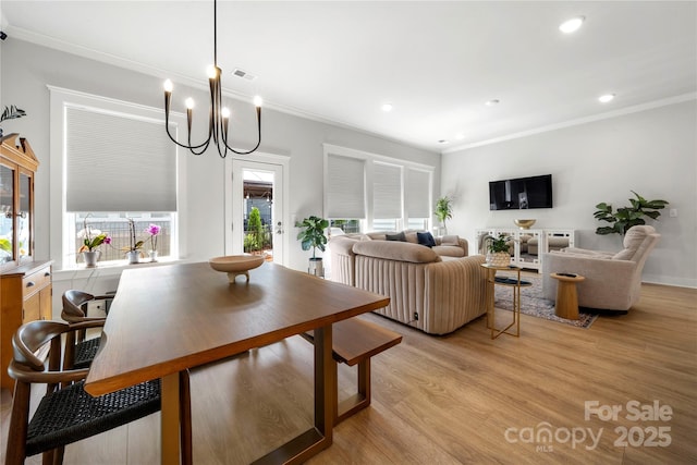 dining space with visible vents, crown molding, light wood-type flooring, an inviting chandelier, and recessed lighting