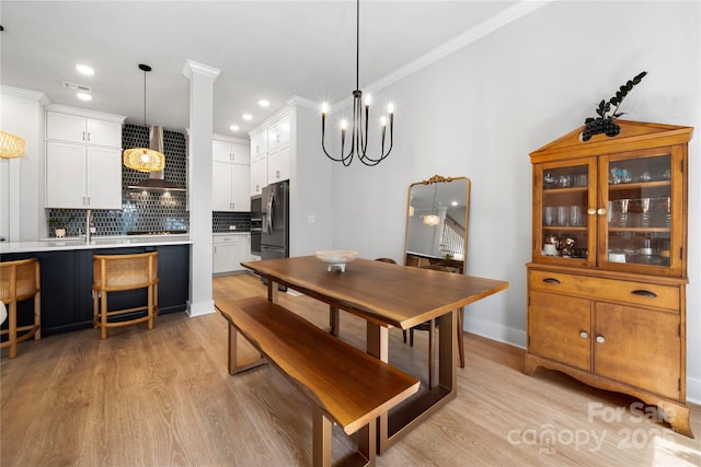 dining room featuring an inviting chandelier, recessed lighting, ornamental molding, and light wood finished floors