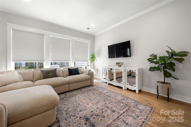 living area with light wood-style floors, recessed lighting, baseboards, visible vents, and ornamental molding
