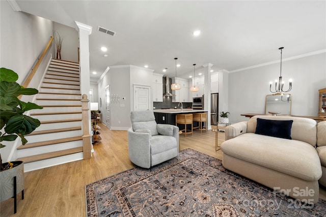 living area with visible vents, crown molding, light wood-style floors, stairway, and recessed lighting