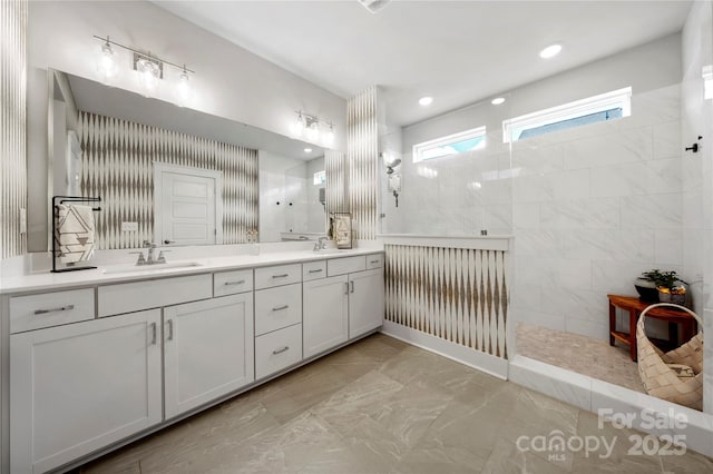 full bath with a sink, walk in shower, double vanity, and marble finish floor