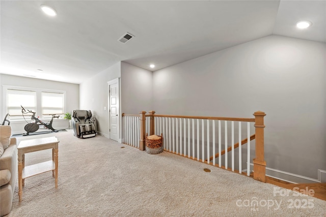 living area with recessed lighting, visible vents, and an upstairs landing