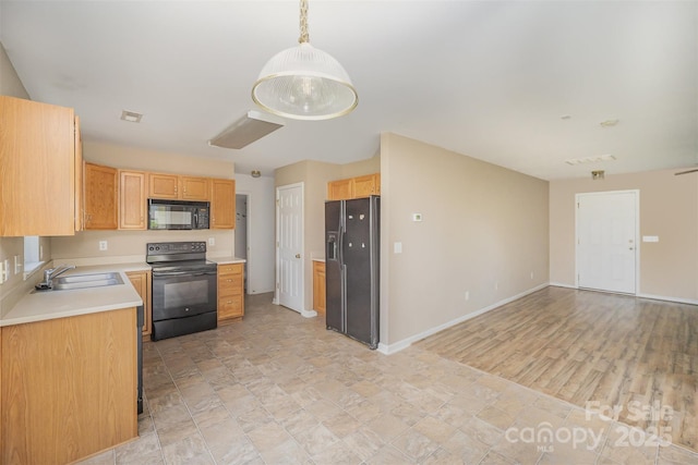kitchen featuring a sink, light countertops, baseboards, black appliances, and open floor plan