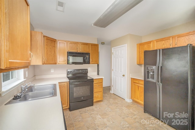 kitchen featuring visible vents, a sink, black appliances, and light countertops