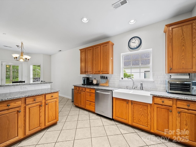kitchen featuring a toaster, backsplash, dishwasher, a sink, and visible vents