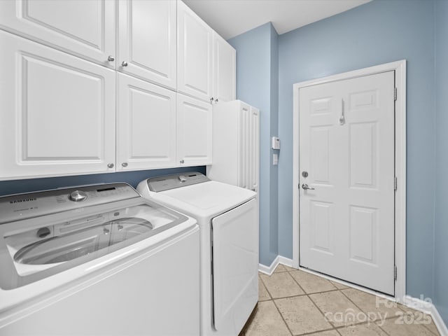 laundry area featuring baseboards, washer and dryer, and cabinet space