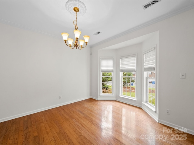 unfurnished room featuring visible vents, an inviting chandelier, ornamental molding, baseboards, and light wood-type flooring