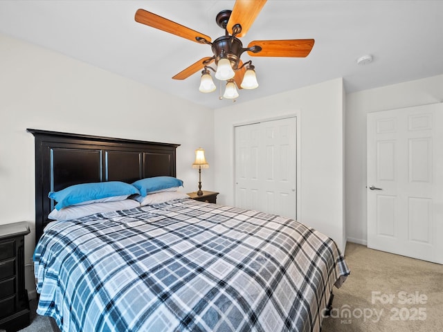 bedroom featuring a ceiling fan, light carpet, and a closet