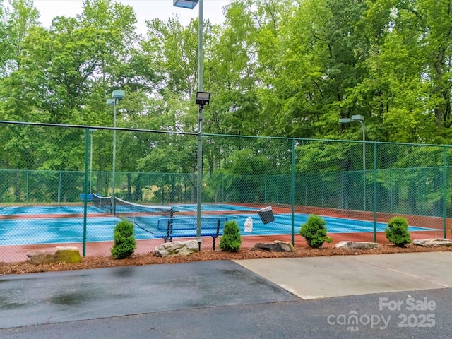 view of tennis court featuring fence