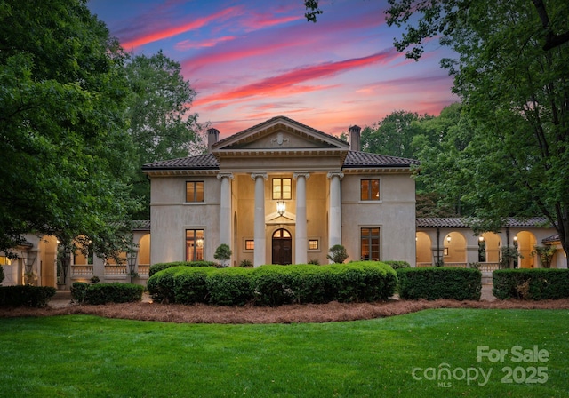 5030 Hardison Rd, Charlotte, NC 28226 - neoclassical home featuring a chimney, a lawn, stucco siding, and a tile roof