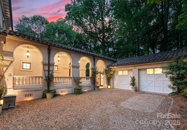5030 Hardison Rd, Charlotte, NC 28226 - view of front facade featuring driveway, covered porch, stucco siding, and a tile roof