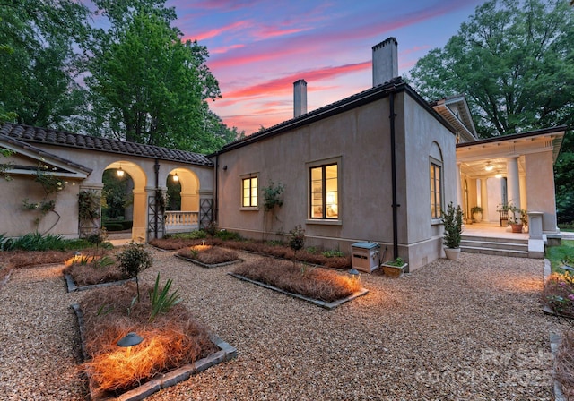5030 Hardison Rd, Charlotte, NC 28226 - rear view of house featuring covered porch, a chimney, and stucco siding