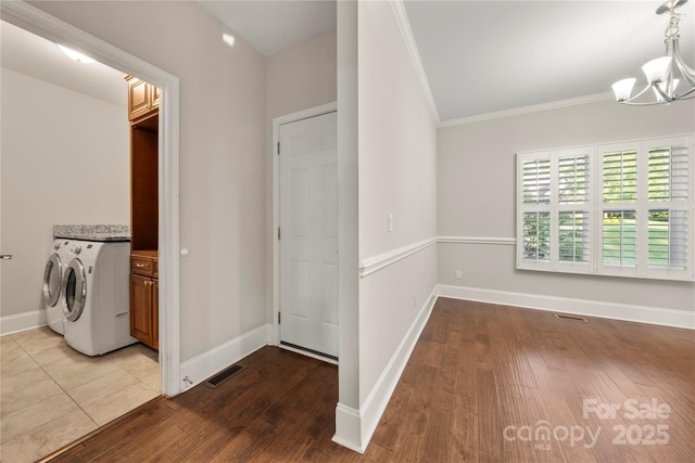 444 Snapdragon Dr, Clover, SC 29710 - washroom with cabinet space, a chandelier, ornamental molding, washing machine and clothes dryer, and wood finished floors