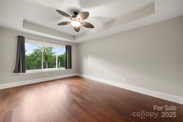444 Snapdragon Dr, Clover, SC 29710 - unfurnished room featuring a raised ceiling, baseboards, a ceiling fan, and dark wood-style flooring
