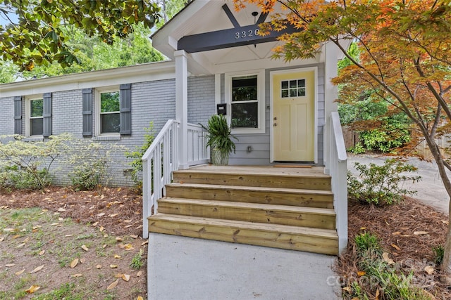 entrance to property featuring brick siding