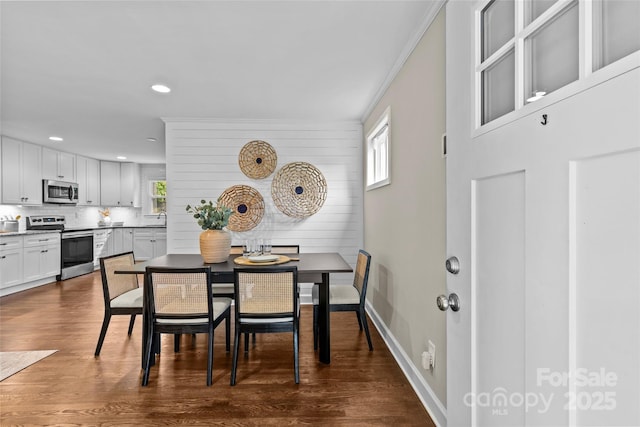 dining room featuring recessed lighting, ornamental molding, baseboards, and dark wood-style floors