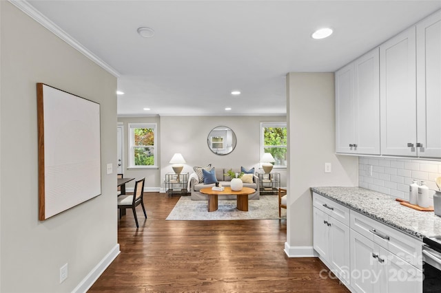 interior space featuring crown molding, baseboards, recessed lighting, dark wood-type flooring, and plenty of natural light