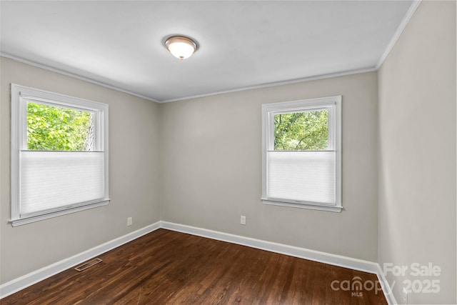 empty room featuring baseboards, ornamental molding, and a wealth of natural light