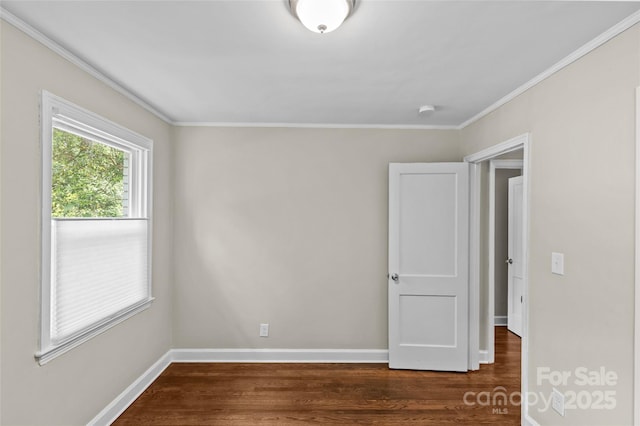 empty room with crown molding, baseboards, and wood finished floors