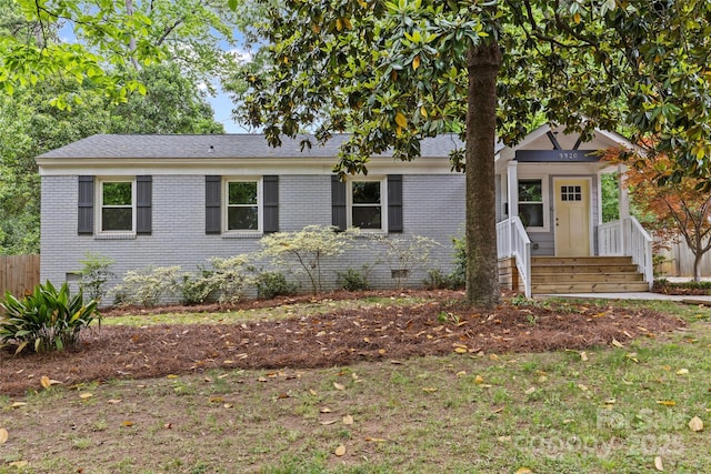 ranch-style house with fence, a shingled roof, crawl space, and brick siding