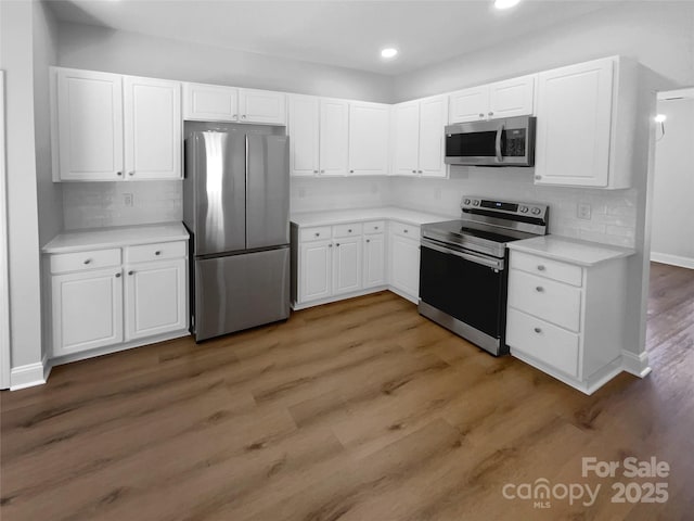 9830 Sandman Ln, Charlotte, NC 28216 - kitchen featuring light countertops, appliances with stainless steel finishes, white cabinetry, and recessed lighting