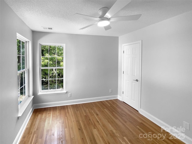 9830 Sandman Ln, Charlotte, NC 28216 - unfurnished room with wood finished floors, visible vents, baseboards, a textured ceiling, and ceiling fan