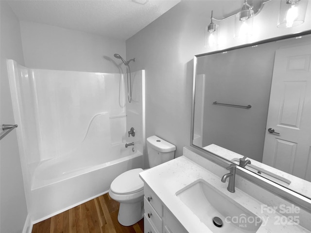 9830 Sandman Ln, Charlotte, NC 28216 - bathroom featuring wood finished floors, toilet, vanity,  shower combination, and a textured ceiling
