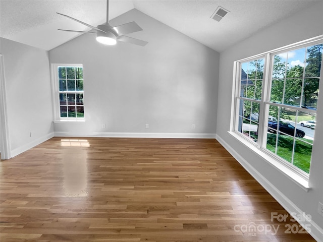 9830 Sandman Ln, Charlotte, NC 28216 - unfurnished room featuring ceiling fan, vaulted ceiling, wood finished floors, and visible vents