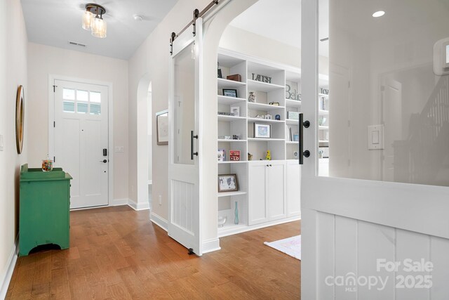 4902 Looking Glass Trl, Denver, NC 28037 - entrance foyer featuring visible vents, arched walkways, a barn door, baseboards, and light wood finished floors