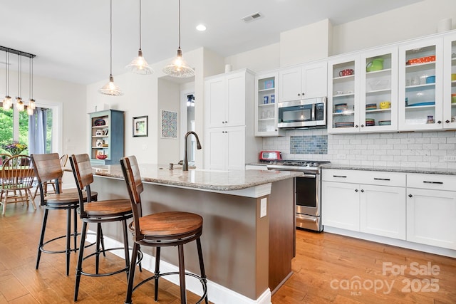 4902 Looking Glass Trl, Denver, NC 28037 - kitchen with backsplash, stainless steel appliances, light stone counters, and light wood-style flooring