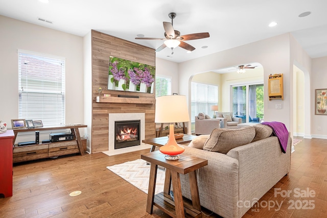 4902 Looking Glass Trl, Denver, NC 28037 - living room with ceiling fan, visible vents, arched walkways, a tile fireplace, and hardwood / wood-style floors