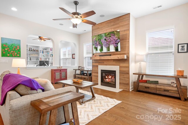 4902 Looking Glass Trl, Denver, NC 28037 - living area with ceiling fan, visible vents, arched walkways, a large fireplace, and hardwood / wood-style flooring