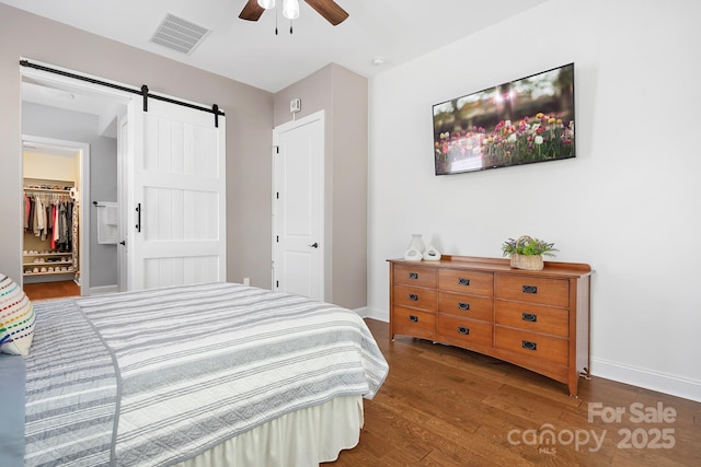 4902 Looking Glass Trl, Denver, NC 28037 - bedroom featuring visible vents, a barn door, wood finished floors, baseboards, and a spacious closet