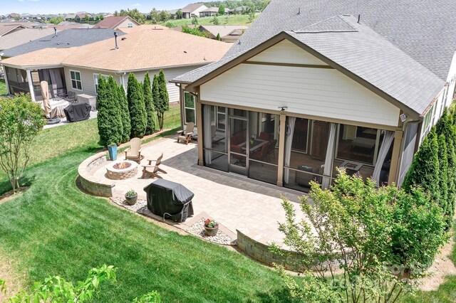 4902 Looking Glass Trl, Denver, NC 28037 - rear view of property with roof with shingles, a sunroom, a lawn, a patio, and a fire pit