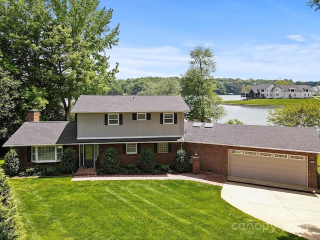 traditional home with a garage, a front yard, driveway, and brick siding