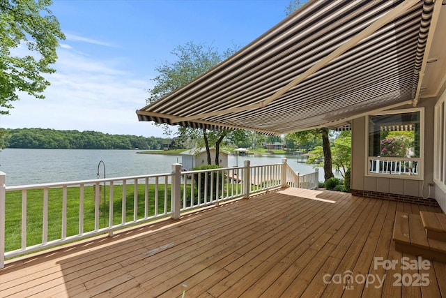 wooden deck featuring a lawn and a water view