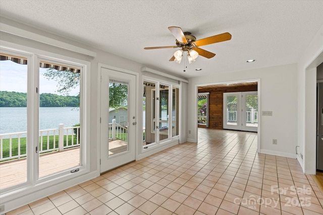 unfurnished sunroom with a water view and french doors