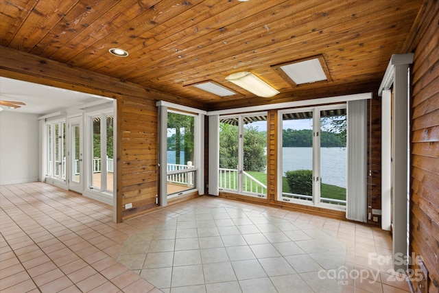 unfurnished sunroom featuring french doors and a water view